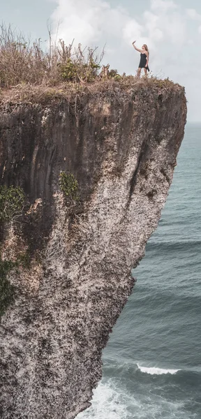 かなり女の子が驚くべき海と曇り空の景色と崖の上に立っている間 Selfie — ストック写真