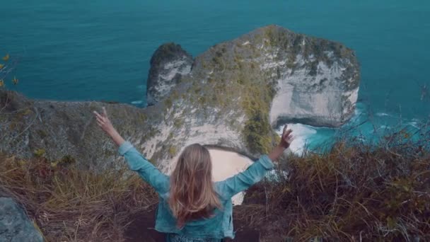 Back View Girl Sitting Cliff Raising Hands Beautiful Kelingking Beach — Stock Video