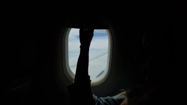 特写乘客的女性手打开和关闭飞机的窗口 在飞机上的机翼上空飞行云 — 图库视频影像