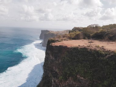 Bali güzel Uluwatu kayalıklardan okyanus ve bulutlu gökyüzü arka plan, Endonezya