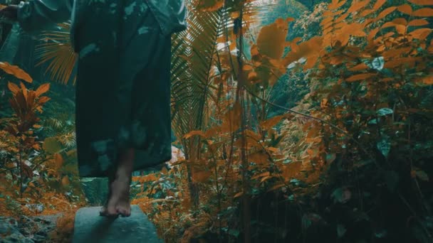 滝の近くの熱帯雨林のジャングルに身を包んだ美しいファッションの女の子 スタイリッシュなヒップスター女性の屋外の肖像画 — ストック動画