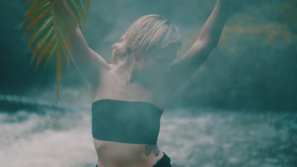 美丽的时尚女孩摆姿势 身体和脸上布满泥在热带雨林丛林附近的瀑布池塘 时尚时髦女性户外肖像 — 图库视频影像