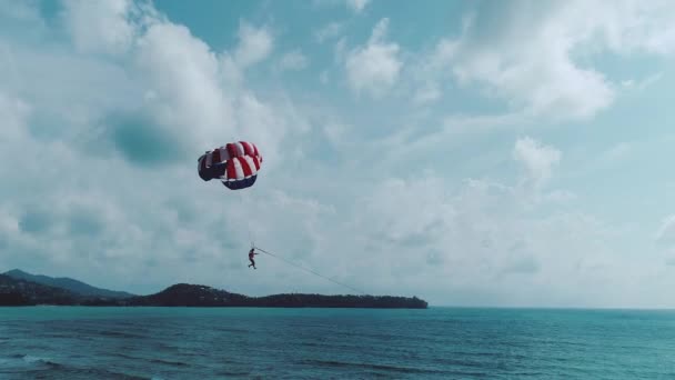 Mann Fliegt Einem Bunten Fallschirm Gegen Den Blauen Wolkenverhangenen Himmel — Stockvideo