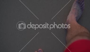 Kumlu sahilde yürüyen adam. Closeup erkeğin ayaklarınızı yıkadım dalgalar tarafından deniz - ağır çekim pov shot