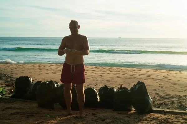 Hombre Feliz Turista Pie Playa Con Bolsas Recogidas Basura Sobre — Foto de Stock