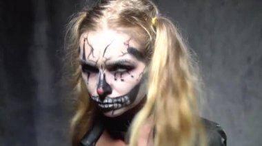 Ürpertici Halloween palyaço kafatası makyaj kameraya bakarak kadınla closeup yüzü. Yaratıcı, sanatsal, Cadılar Bayramı kavramı - ağır çekim video