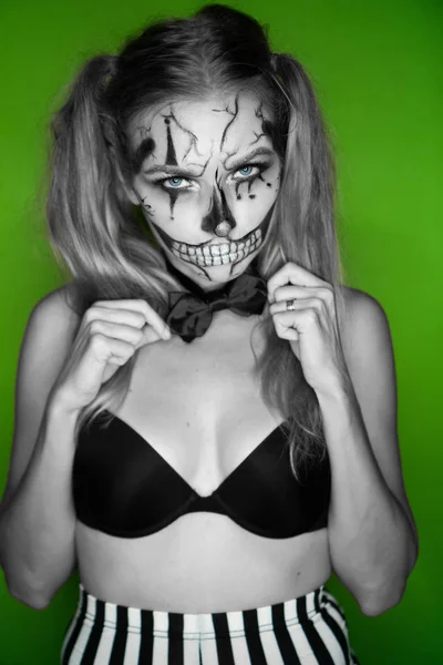 Woman with creepy Halloween clown skull makeup looking into the camera. Creative, artistic, Halloween concept