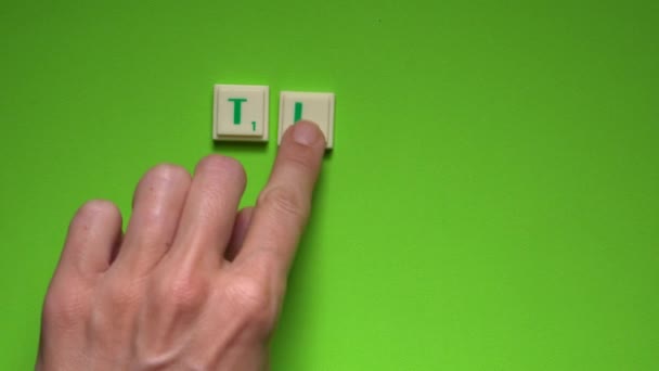 Ženská ruka vytváření slova časový harmonogram s písmeny na zeleném pozadí