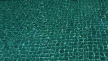 Mavi su yüzey yüzme havuzlu. Su ripples ve mavi mozaik döşeli yüzme havuzu arka plan döşenir