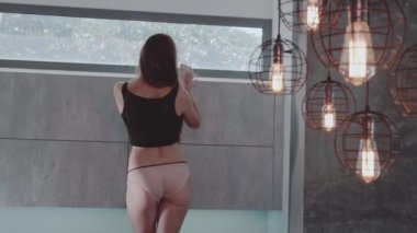 Güzel kızıl saçlı kız üst ve vintage sanayi tarzı lambalar mutfakta - ağır çekimde video yakın poz külot