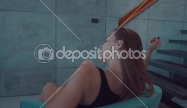 Güzel kızıl saçlı kız üst ve külot üzerinde dönen onun evinde modern iç - ağır çekimde video rahat bir sandalye