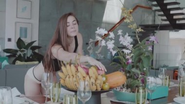 Güzel mutlu kızıl saçlı kız üst ve onun evinde modern iç - ağır çekimde video bir elma yemek külot