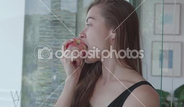 Onun evinde - ağır çekimde video bir elma yemek güzel kızıl saçlı kız closeup yüzü