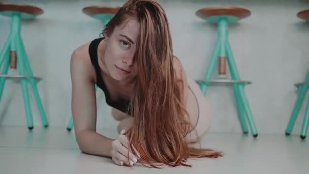 美丽的红头发女孩在顶部和内裤摆姿势在现代室内厨房的地板上 视频慢动作 — 图库视频影像