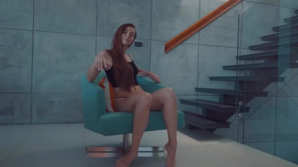 美丽的红头发女孩在顶部和内裤旋转在舒适的椅子上 在她的现代内部房子 视频慢动作 — 图库视频影像