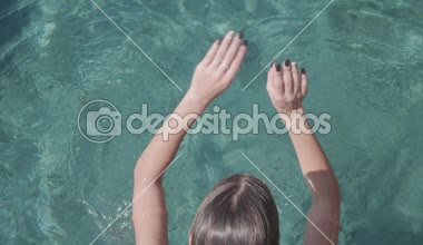 Üstten görünüm açık yüzme havuzunda - ağır çekimde video sualtı dalış genç güzel kadın geri