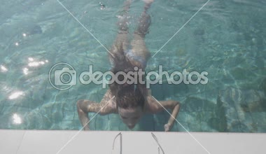 Üstten görünüm açık yüzme havuzunda - ağır çekimde video sualtı dalış genç güzel kadın geri