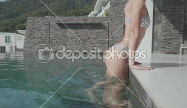 Bikini ve sudan çıkan ve yürüyüş güneş gözlüğü açık havuzun kenarında - duşa ağır çekim video kadın genç güzel