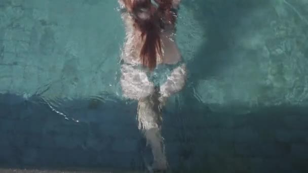 日当たりの良い夏の日 スローモーションのビデオの中に屋外プールで泳ぐ若いきれいな女性 — ストック動画