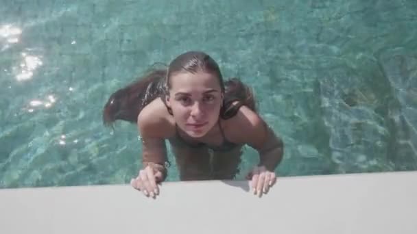 年轻漂亮的女人看着镜头 在阳光明媚的夏日在室外游泳池游泳后 慢动作视频 — 图库视频影像