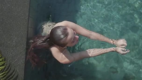 日当たりの良い夏の日 スローモーションのビデオの中に屋外プールで泳いだ後 カメラに探している若いきれいな女性のトップ ビュー — ストック動画