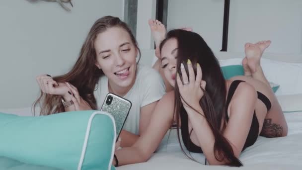 モダンなインテリアの家のベッドの上に横たわっている間 Selfie 写真をやって幸せな女性の友人 自由な時間 友人コンセプト スローモーションのビデオとの週末 — ストック動画