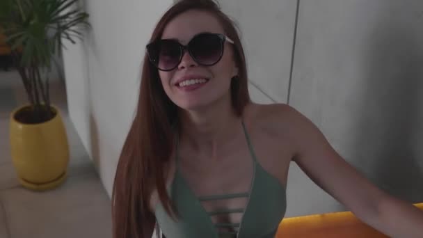 彼女の近代的なインテリアハウスの階段を歩くビキニとサングラスの美しい赤い髪の女の子 スローモーションでビデオ — ストック動画