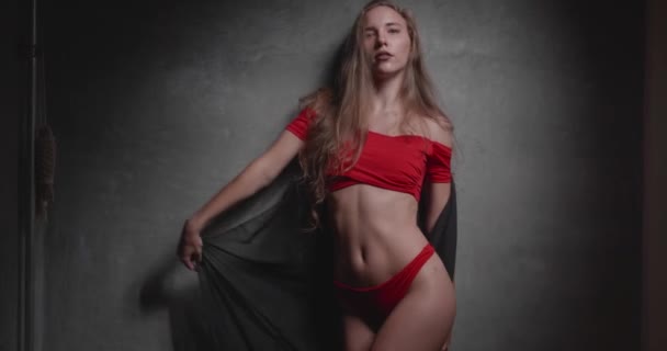赤いビキニと黒灰色の壁背景に全体的なポーズの美しい若い女性 — ストック動画