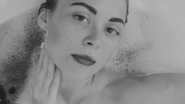 Pohled shora closeup tvář ženy při pohledu do kamery v lázni - černé a bílé video v pomalém pohybu