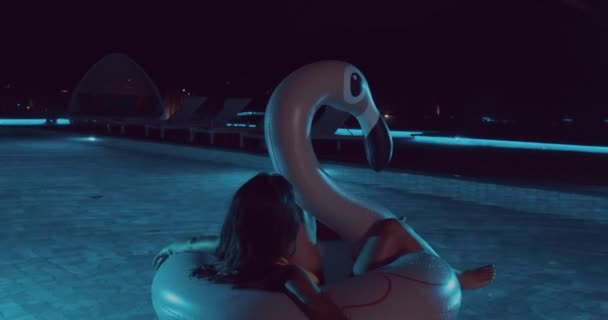 Schöne Frau Gelben Bikini Liegt Nachts Auf Rosa Aufblasbarem Flamingo — Stockvideo