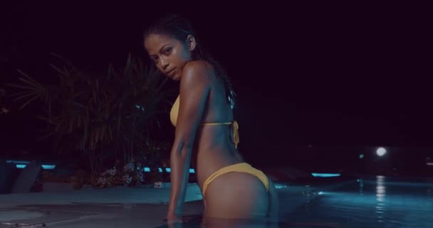 Mooie Vrouw Een Gele Bikini Poseren Het Buitenzwembad Tijdens Nacht — Stockvideo