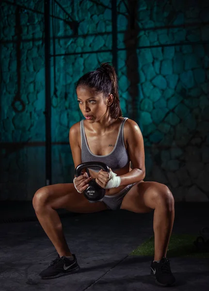 Foto de Jovem Esportiva Fazendo Agachamentos Sumô Com Kettlebell