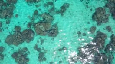 Mercan resifi ve güneş ışınları ile kristal berraklığında lagün deniz suyu yüzeyinin havadan drone üst görünümü