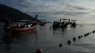 Gün batımında denizde yüzen ahşap uzun kuyruk tekneleri Amazing hava drone atış tarafı