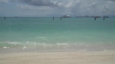 Ahşap yığınları kristal berrak deniz suyunda teknelerin üzerinde ve bulutlu gökyüzü arka planında