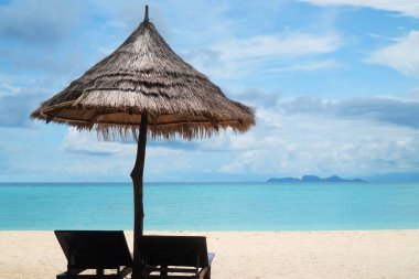 Şezlonglar, lagün deniz ve gökyüzü arka plan üzerinde şemsiye ile Amazing tropikal plaj. Tropikal tatil, tatil, seyahat konsepti