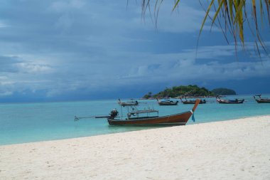 Kumlu plaj ve deniz bulutlu gökyüzü üzerinde tekneler ile. Tayland Koh Lipe güzel tropikal ada