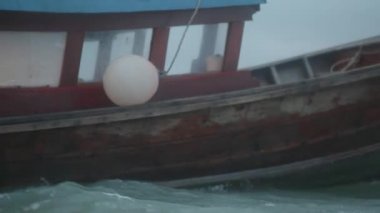 Bulutlu karanlık gökyüzü arka planda dalgalı denizde sürüklenerek tekne. Sabah erkenden fırtınadan önce huzursuz deniz suyu ve gökyüzü sinematik dramatik görüntüleri