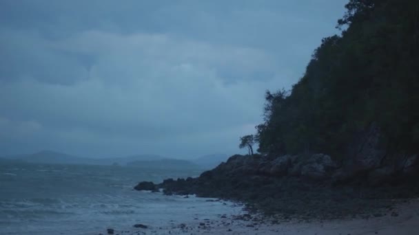 热带岛屿海滩 岩石海岸 不安的大海和树木在暴风雨多云的早晨在风中摇曳 — 图库视频影像