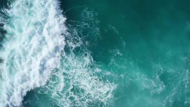 岩の島の海岸に墜落する海の美しい波の空中ドローントップビュー — ストック動画