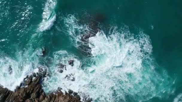 岩の島の海岸に墜落する海の美しい波の空中ドローントップビュー — ストック動画