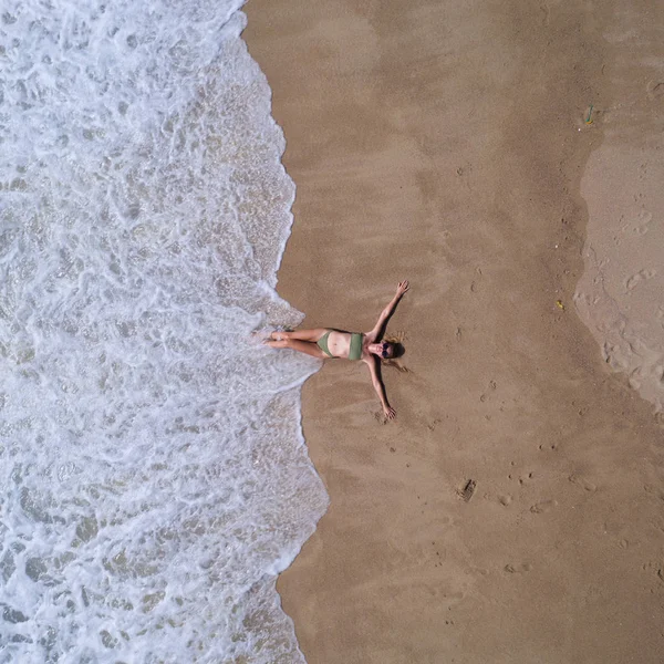 海の近くの砂浜に横たわって 彼女の手を伸ばした女性の空中トップビュー 夏休みのコンセプト — ストック写真
