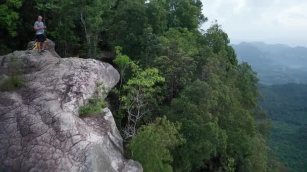 Vista Aérea Pareja Borde Roca Sobre Hermosas Montañas Verdes Fondo — Vídeo de stock