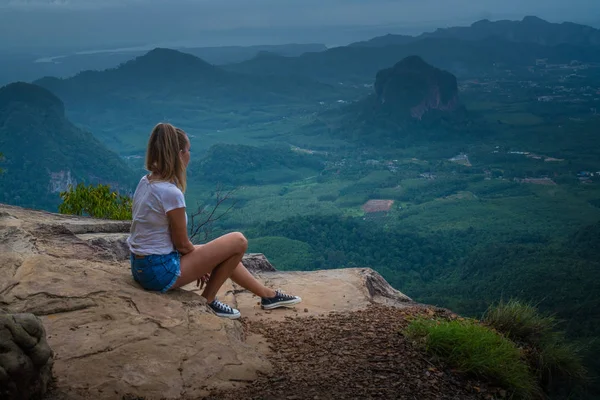 女人塔维勒坐在悬崖上 看着美丽的风景与山脉和山谷与多云的早晨天空 — 图库照片