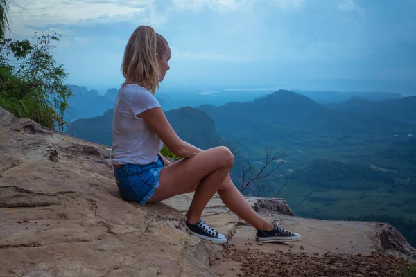 女人塔维勒坐在悬崖上 看着美丽的风景与山脉和山谷与多云的早晨天空 — 图库照片