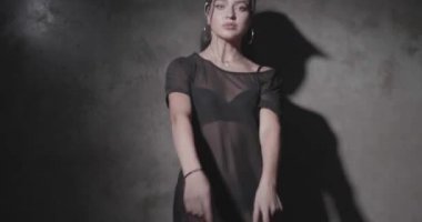 Siyah giyen şehvetli kadın t-shirt, iç çamaşırı ve güneş lik örüntü sidans gri beton duvarlar ile stüdyoda görmek 