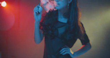 Muhteşem esmer kadın neon renk ışık elektronik sigara - yavaş hareket video