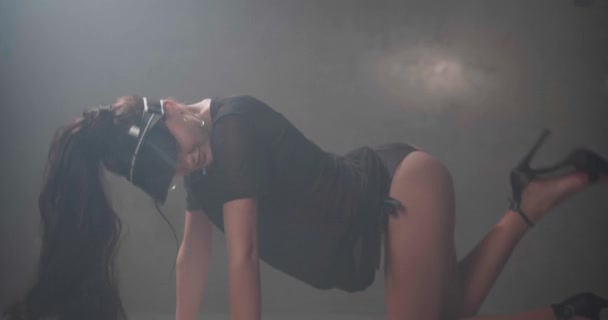 黒い服を着た官能的な女性は 灰色のコンクリートの壁でスタジオの床に踊るTシャツ ランジェリー サンバイザーを通して見る スローモーションでビデオ — ストック動画