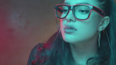 Muhteşem esmer kadın neon renk ışık elektronik sigara - yavaş hareket video