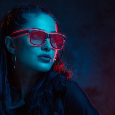 Neon gözlük portre şehvetli kadın. Güzel genç kadın model iwearing oink neon gözlük kibirli duvar arka plan üzerinde kırmızı ışıkta iisoalted